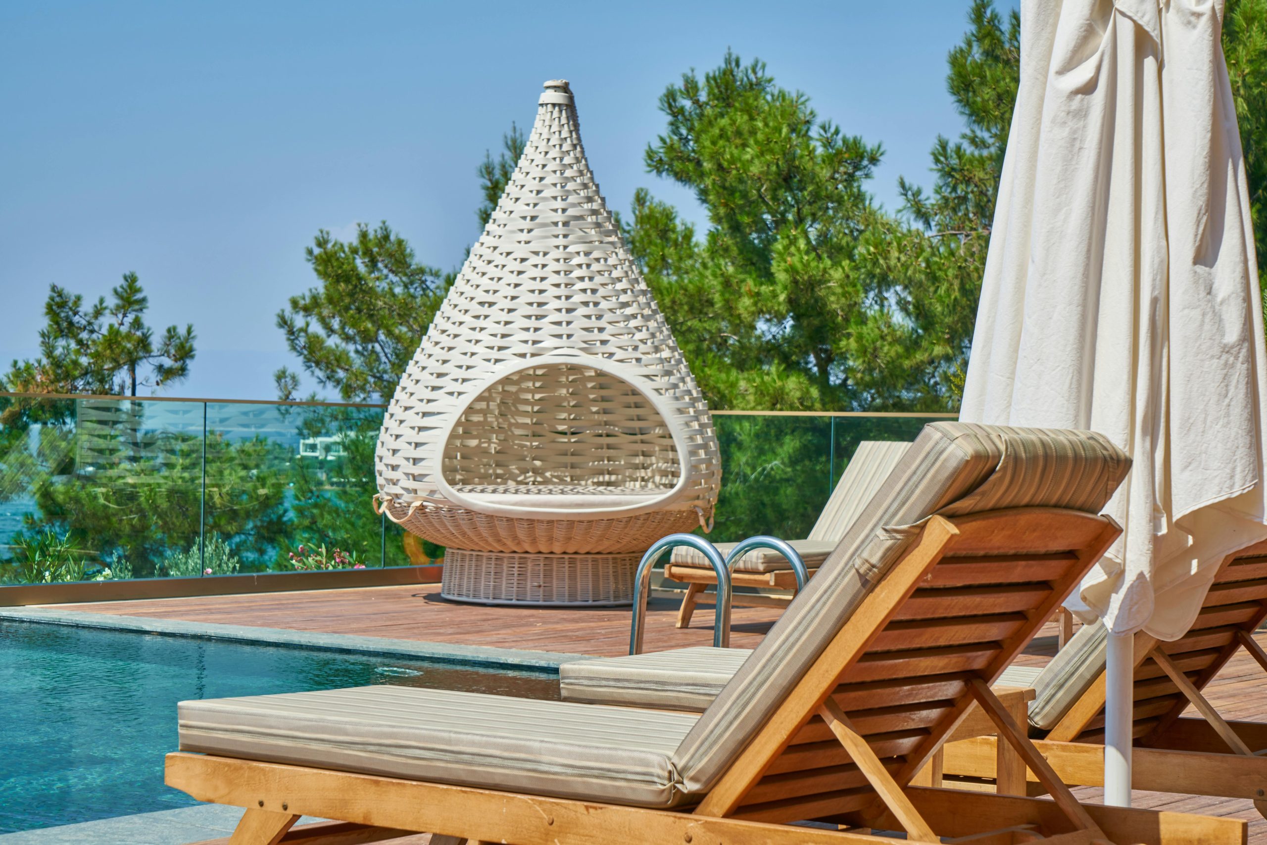 Photo d'un salon de piscine avec chaises longue et bain de soleil.