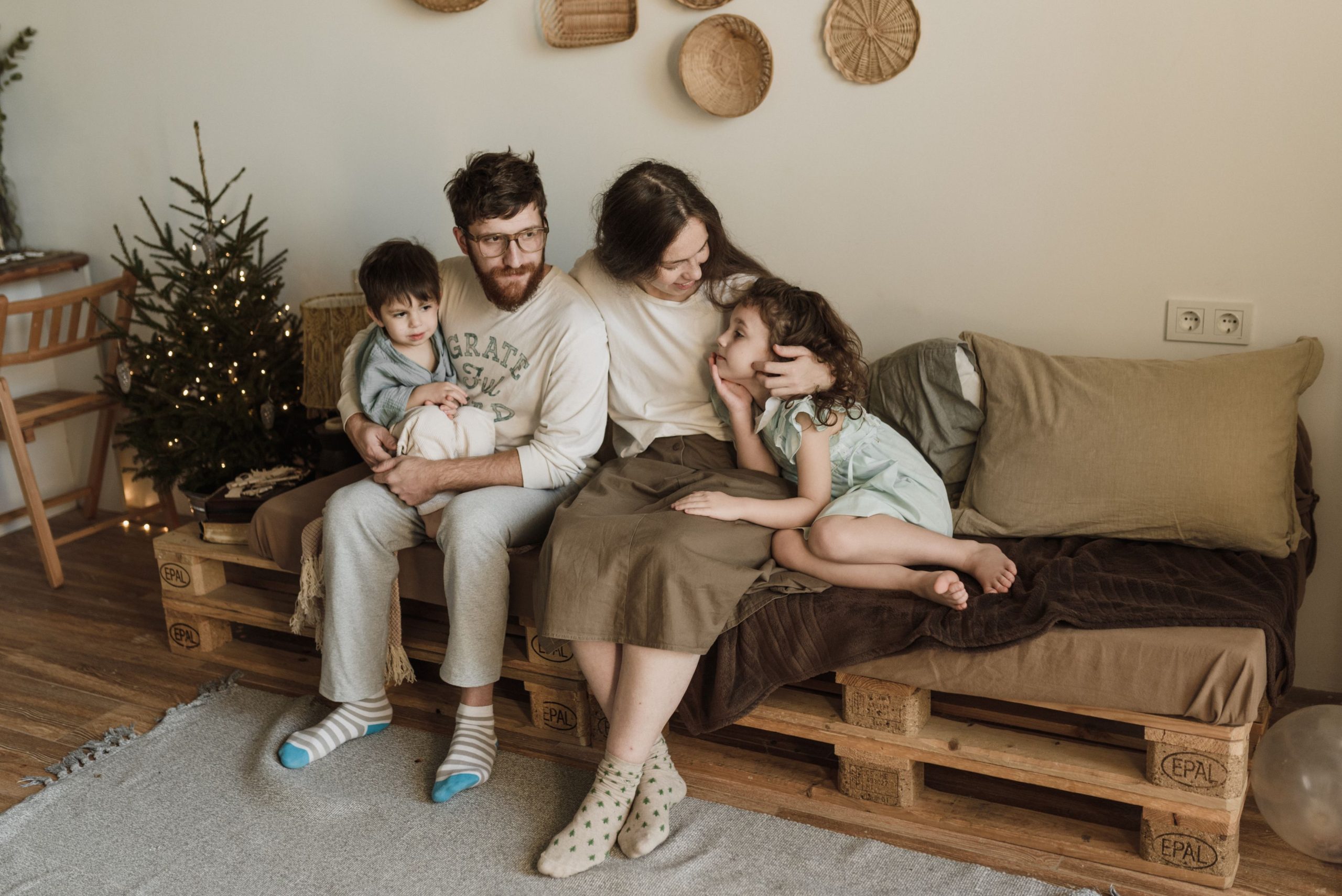 Photo d'une famille sur un canapé palette.